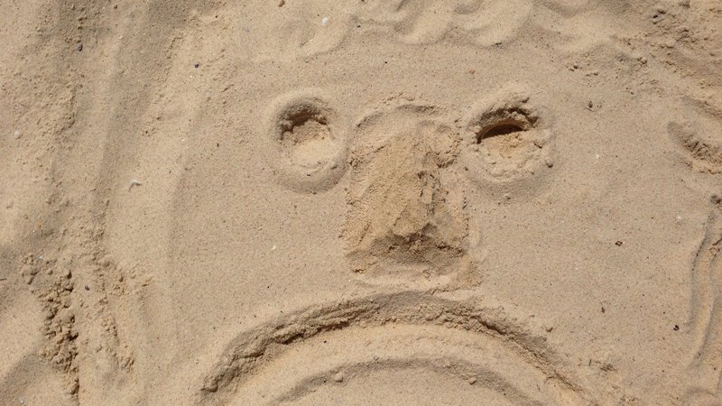Sad face on the sand